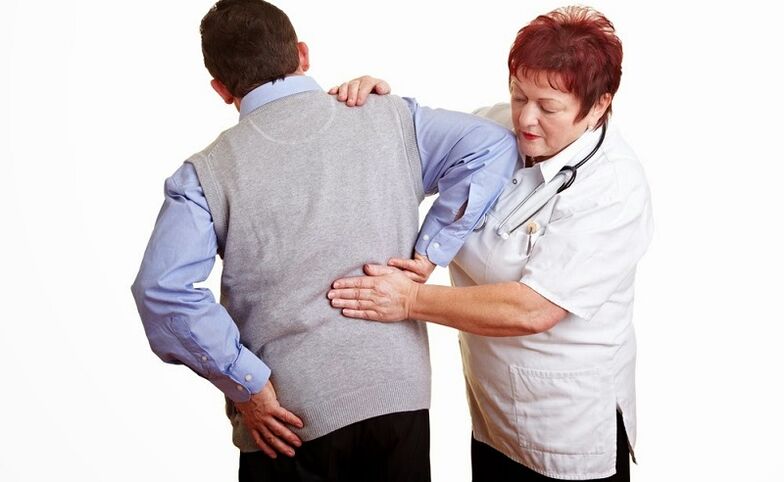 Un médico examina al paciente en busca de dolor de espalda. 
